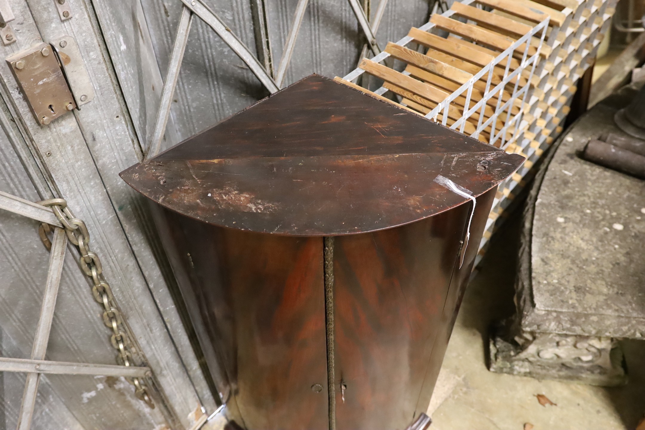 A George III mahogany bowfront hanging corner cabinet with bronze mount, width 66cm, depth 44cm, height 107cm